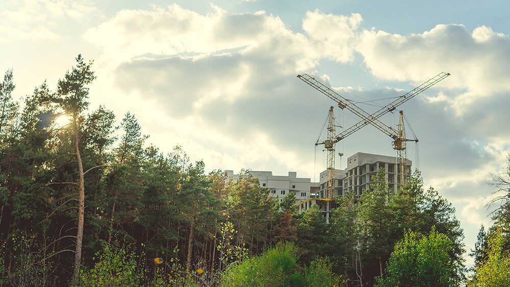 Constructing building with high crane under clear sky depicting an example of a LEED BD+C (LEED Building Design and Construction) building